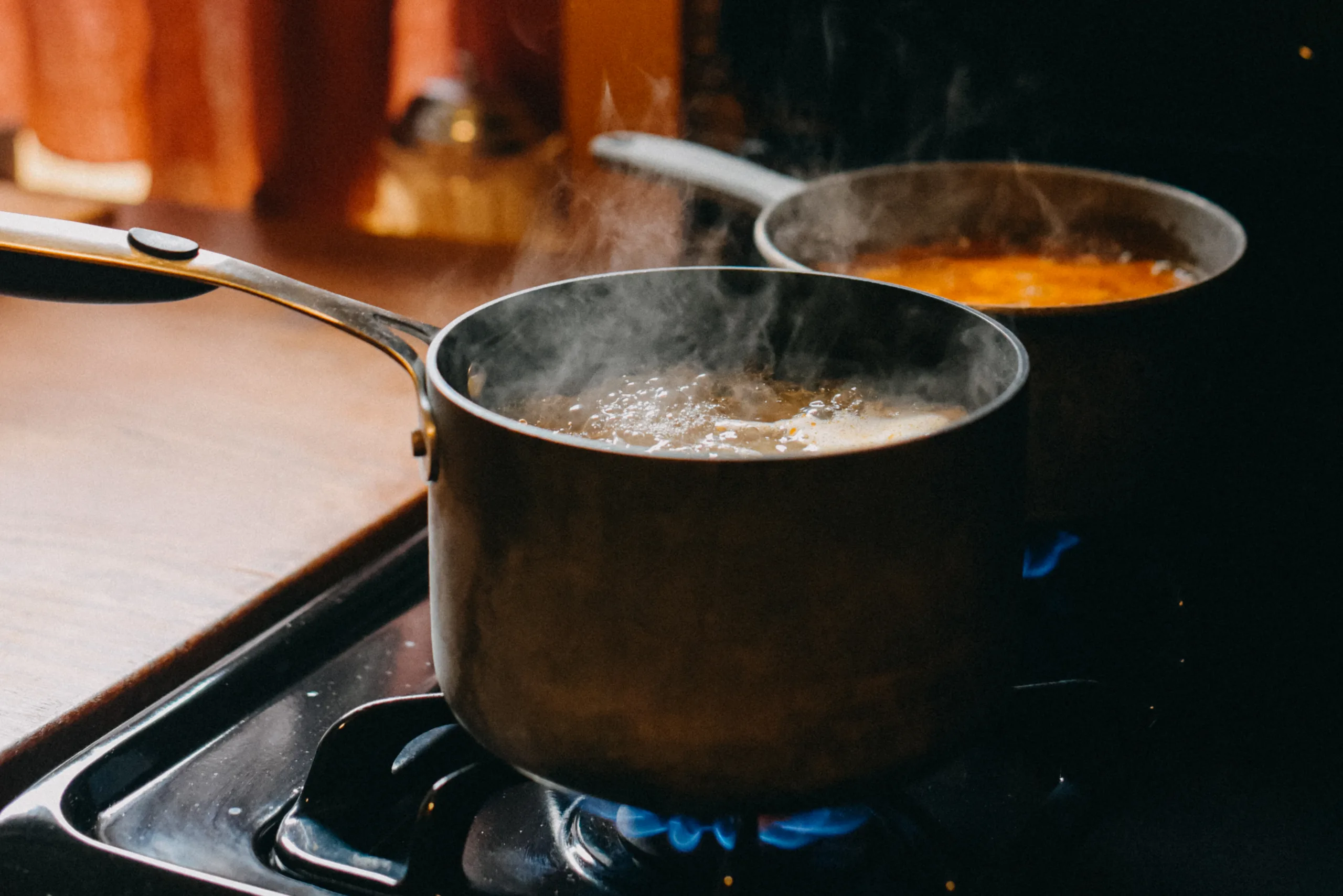 Soup Boiling In Cooking Pans On Gas Burning Stove