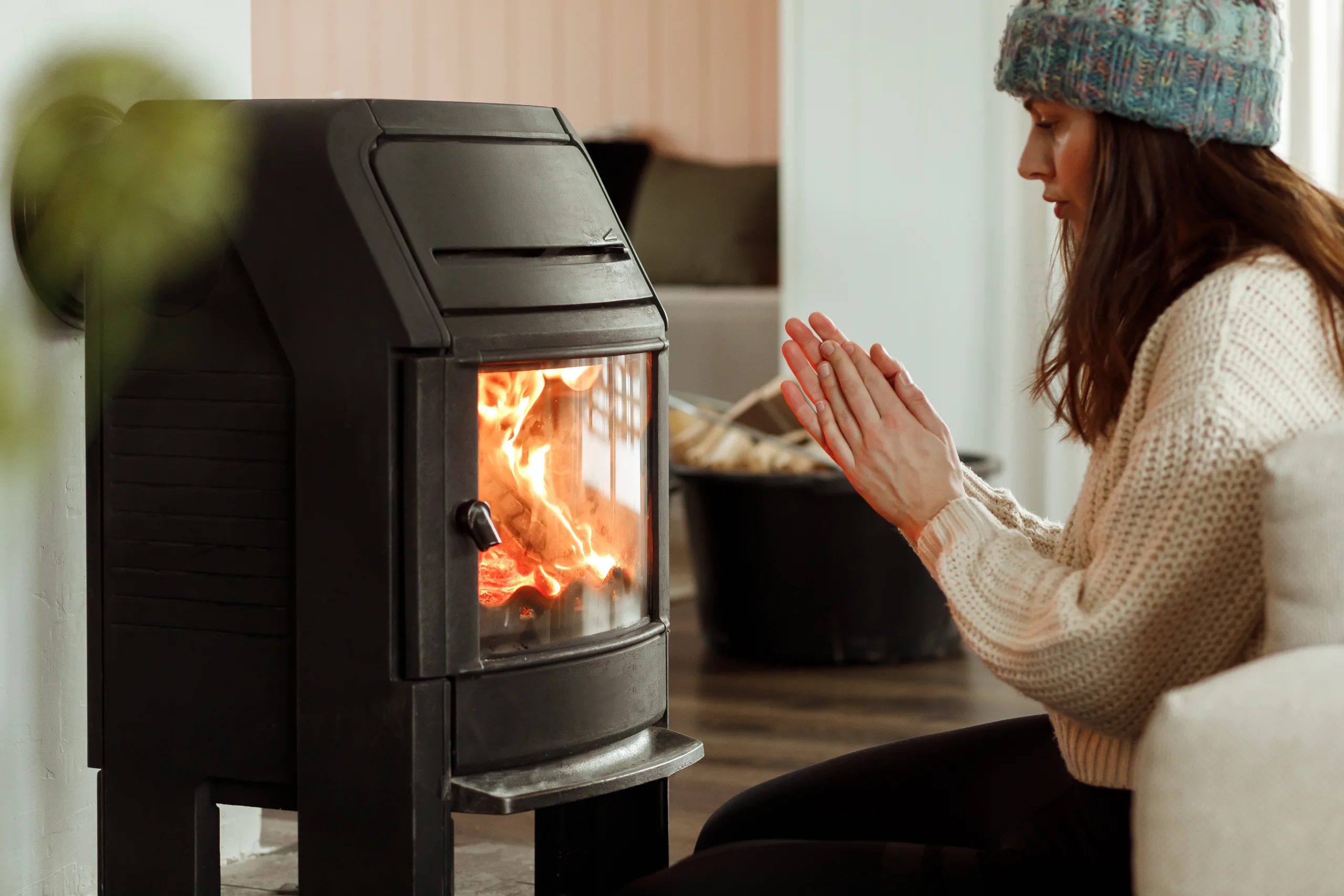 A Woman Sitting By A Fireplace To Warm Up
