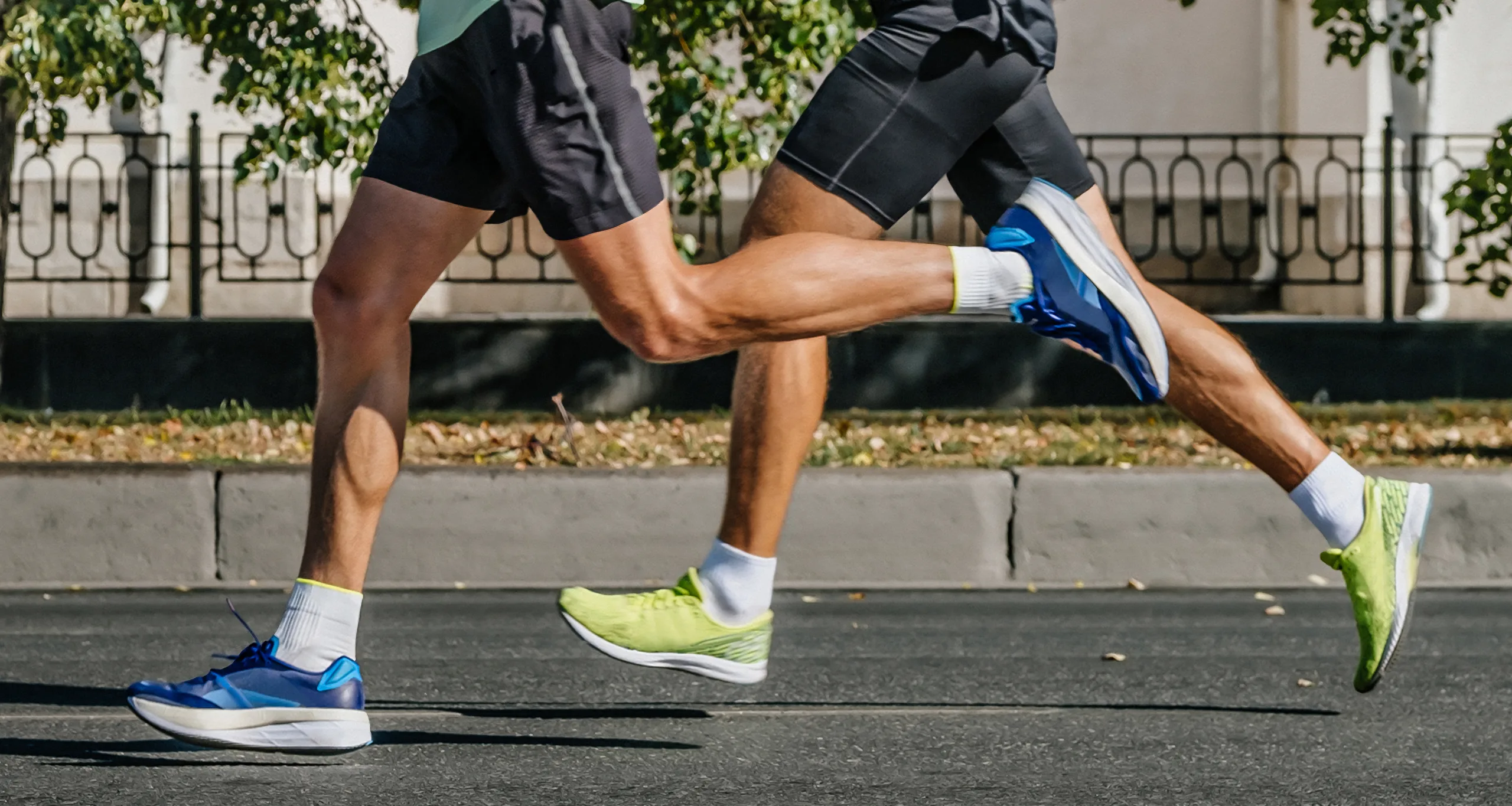 Legs Two Male Runners Running City Marathon Race, Athletes Jogging On Asphalt Road, Summer Sports Games