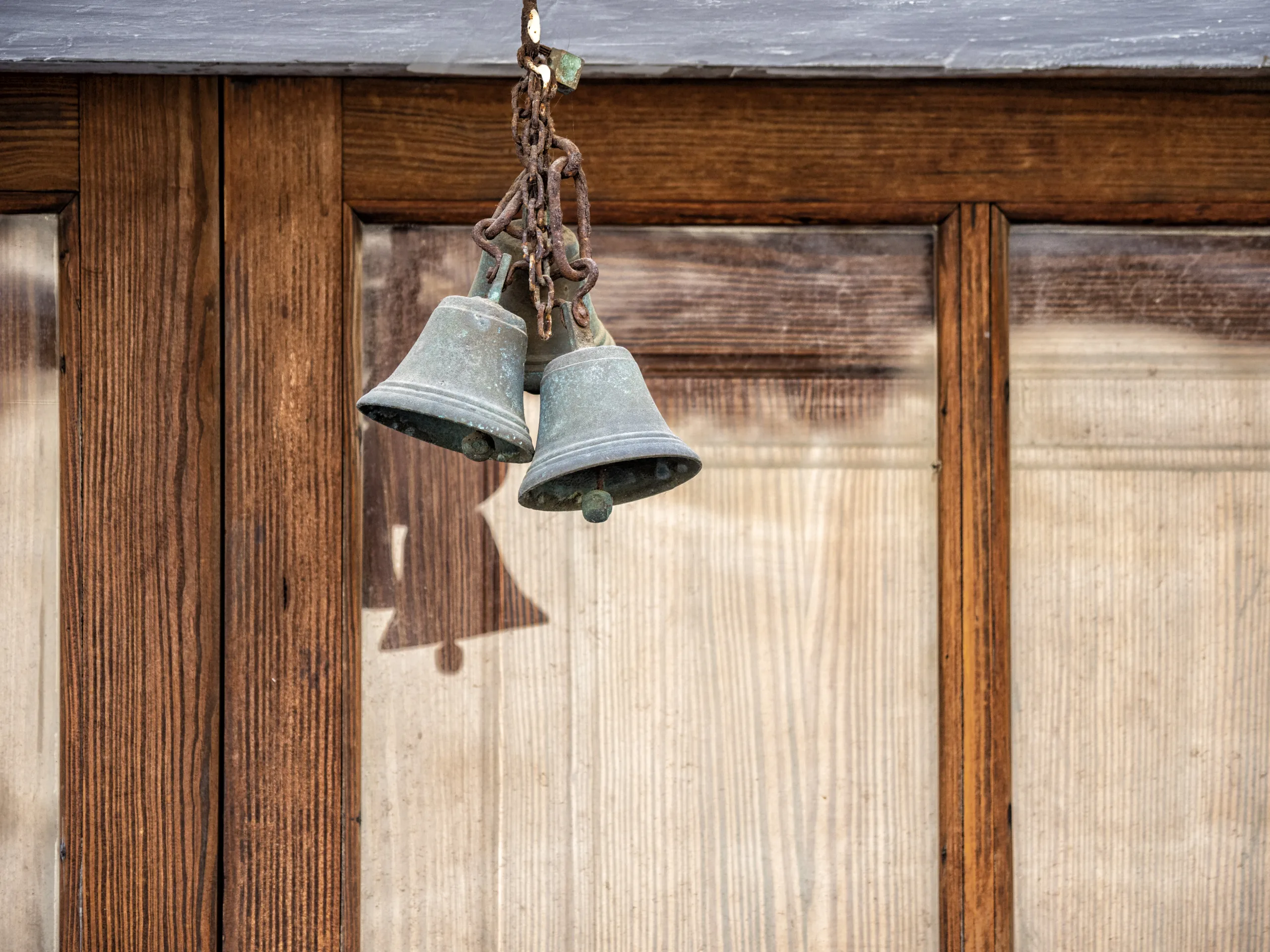 Ancient Door Of Wood In The Street And A Small Metal Bell With A Chain.